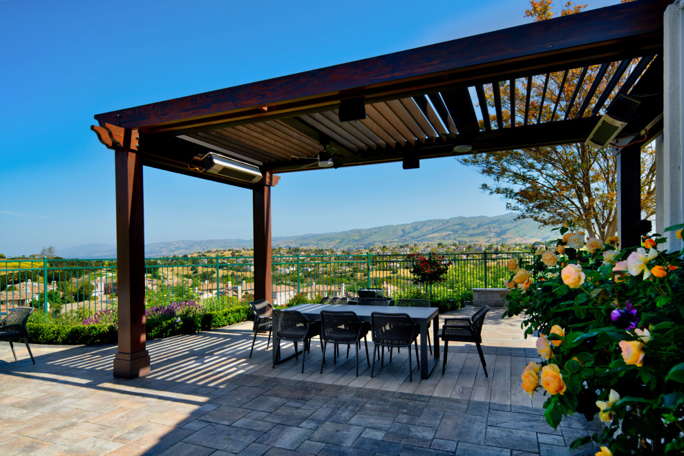 Foto de patio mediterráneo grande en patio lateral con fuente, adoquines de hormigón y pérgola