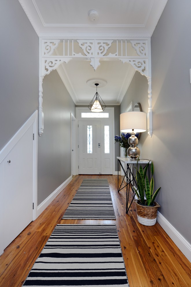 Inspiration for an eclectic hallway in Sydney with grey walls, medium hardwood floors and brown floor.