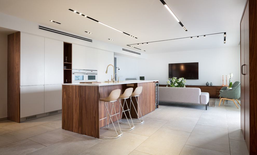 Photo of a large contemporary galley eat-in kitchen in Milan with flat-panel cabinets, white appliances, with island, grey floor, white benchtop and medium wood cabinets.