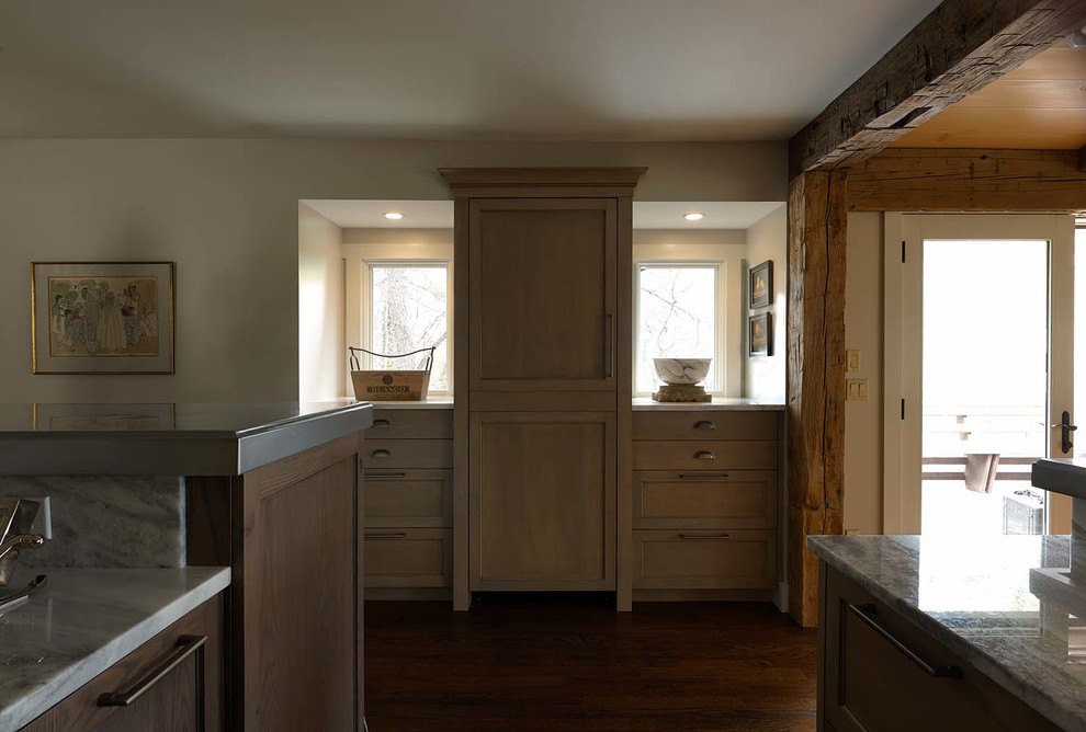 Example of a transitional u-shaped dark wood floor eat-in kitchen design with an undermount sink, recessed-panel cabinets, gray cabinets, white backsplash, stone slab backsplash, stainless steel appliances and an island