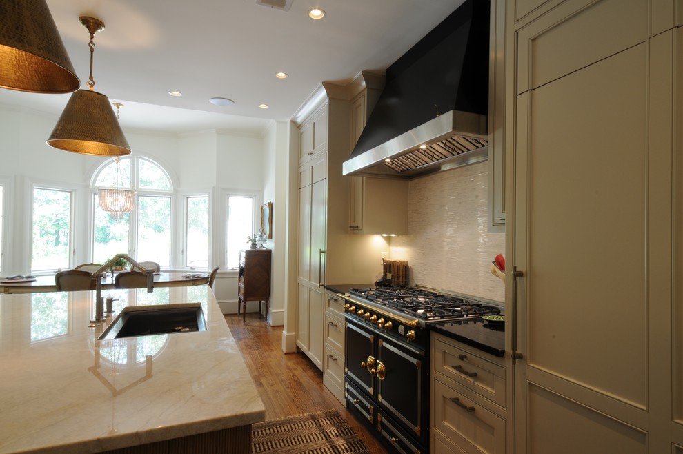 Inspiration for a large transitional u-shaped dark wood floor and brown floor open concept kitchen remodel in Birmingham with an undermount sink, shaker cabinets, white cabinets, granite countertops, white backsplash, mosaic tile backsplash, paneled appliances and an island
