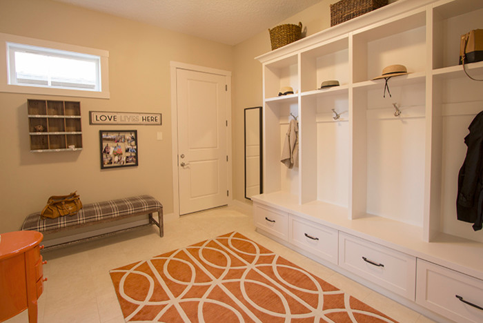 This is an example of a transitional mudroom in Calgary with beige walls, light hardwood floors, a single front door and a white front door.