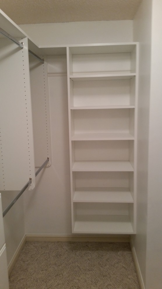 This is an example of a mid-sized traditional gender-neutral walk-in wardrobe in Jacksonville with open cabinets, white cabinets, carpet and beige floor.