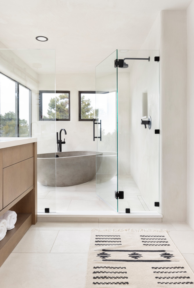 This is an example of a large master wet room bathroom in Albuquerque with flat-panel cabinets, a freestanding tub, porcelain floors, beige floor, a hinged shower door, a double vanity, a built-in vanity and wood.