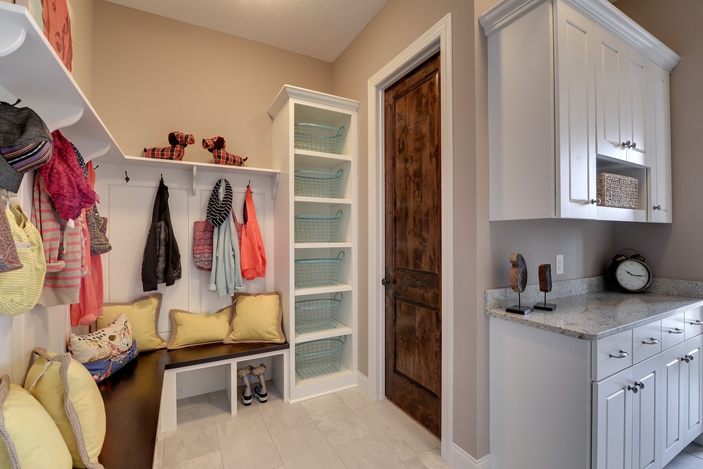 This is an example of a large transitional mudroom in Minneapolis with beige walls, ceramic floors, a single front door and a dark wood front door.