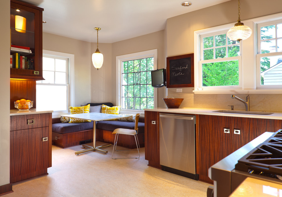 This is an example of a modern eat-in kitchen in Portland with marble benchtops, flat-panel cabinets and dark wood cabinets.