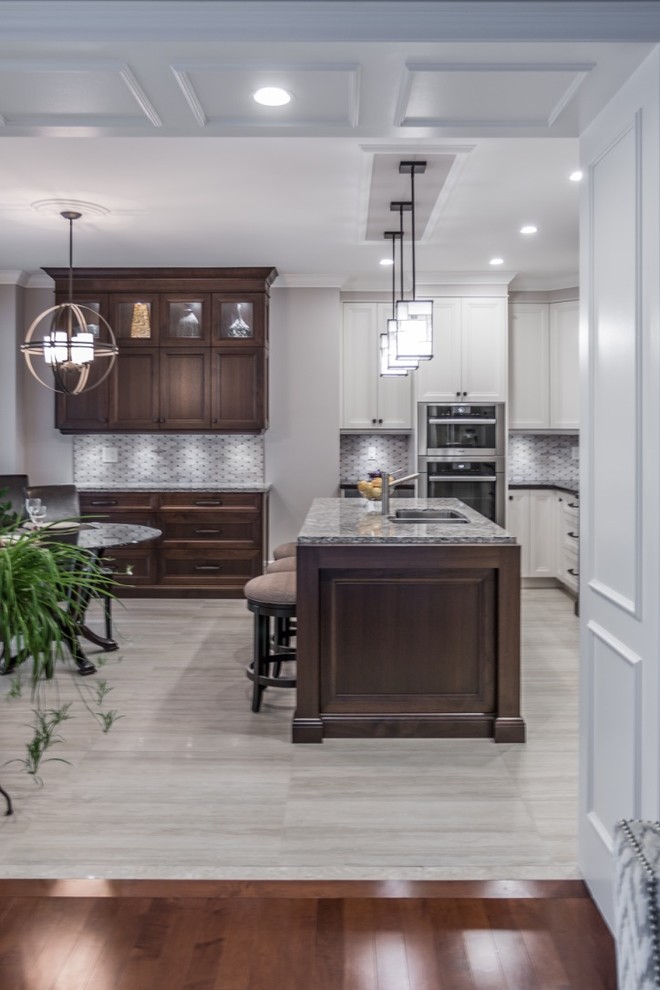 Mid-sized transitional l-shaped ceramic tile eat-in kitchen photo in Toronto with an undermount sink, shaker cabinets, granite countertops, mosaic tile backsplash, stainless steel appliances, an island, gray backsplash and white cabinets
