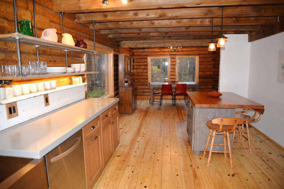 Example of a mid-sized mountain style galley light wood floor open concept kitchen design in Grand Rapids with an undermount sink, recessed-panel cabinets, medium tone wood cabinets, solid surface countertops, white backsplash, stainless steel appliances and an island