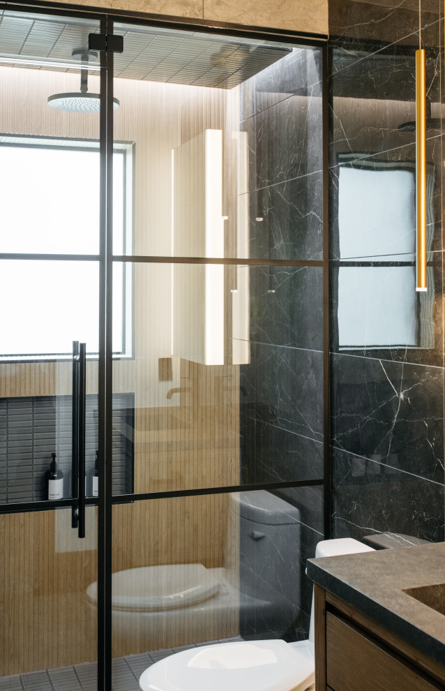 Réalisation d'une salle de bain design en bois brun avec un placard à porte plane, WC à poser, un lavabo intégré, un sol gris, une cabine de douche à porte battante, un plan de toilette gris, une niche, meuble simple vasque et meuble-lavabo suspendu.