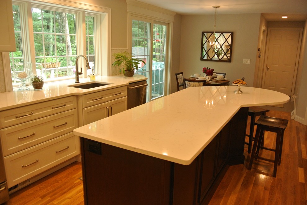 Example of a transitional medium tone wood floor eat-in kitchen design in Boston with an undermount sink, shaker cabinets, quartz countertops, beige backsplash, mosaic tile backsplash, stainless steel appliances, an island and white countertops