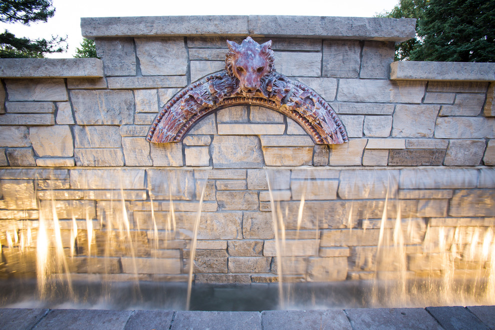Inspiration for a transitional backyard stone water fountain landscape in Omaha.
