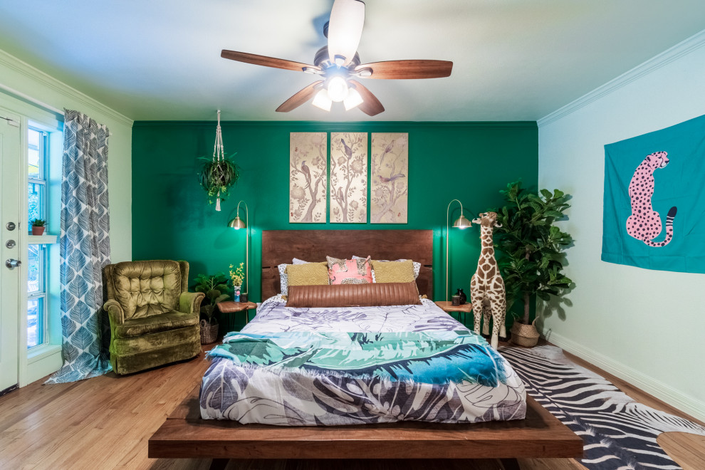 This is an example of a mid-sized eclectic guest bedroom in Dallas with green walls, medium hardwood floors and brown floor.