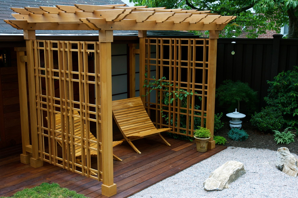 Asian backyard deck in New York with a pergola.
