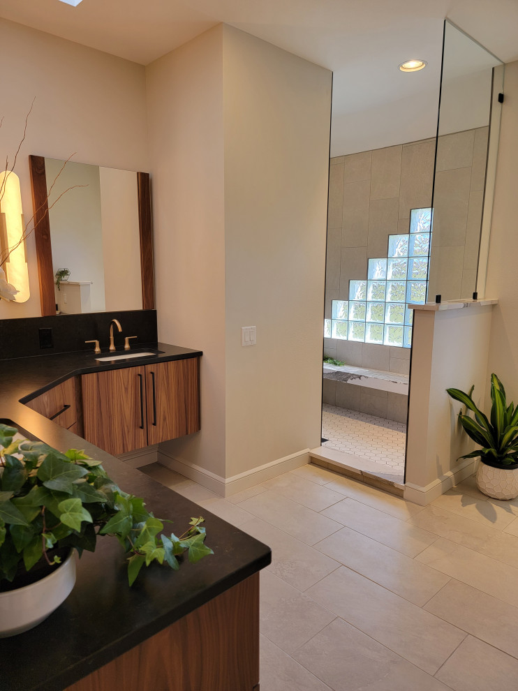 Medium sized modern ensuite bathroom in Burlington with flat-panel cabinets, medium wood cabinets, a submerged sink, engineered stone worktops, beige floors, an open shower, black worktops, a shower bench and double sinks.