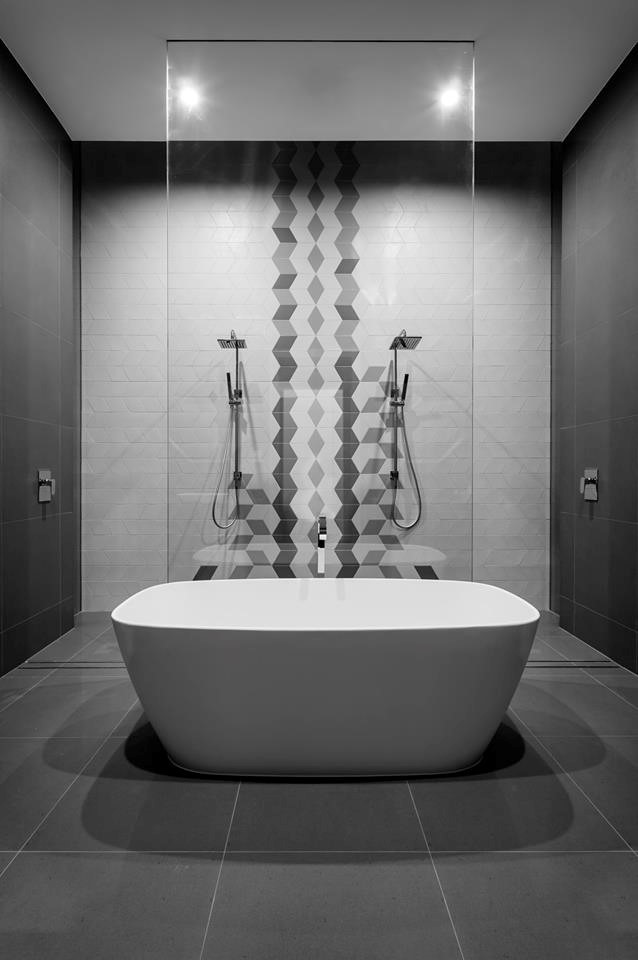 This is an example of a large contemporary 3/4 bathroom in Adelaide with furniture-like cabinets, medium wood cabinets, a freestanding tub, a shower/bathtub combo, gray tile, porcelain tile, grey walls, porcelain floors, a wall-mount sink, wood benchtops, a two-piece toilet, grey floor, an open shower and grey benchtops.