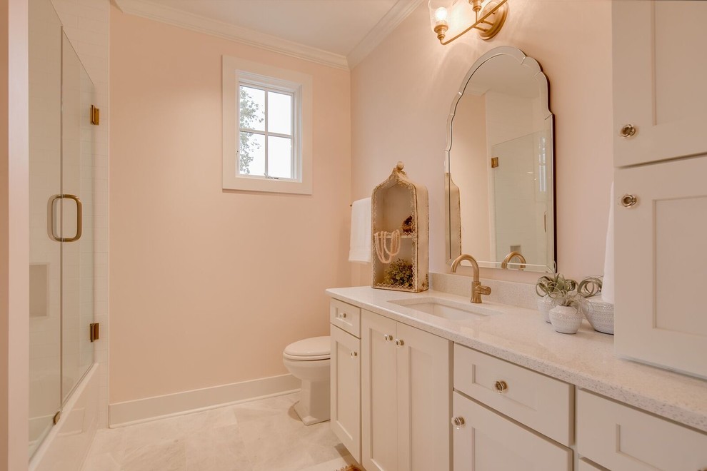 Photo of a large traditional kids bathroom in Other with shaker cabinets, white cabinets, an alcove shower, white tile, marble, an undermount sink, engineered quartz benchtops, a hinged shower door, pink walls, marble floors and grey floor.