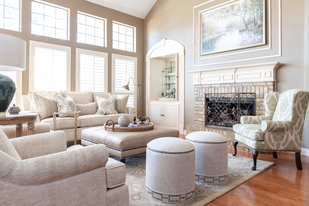 Photo of a mid-sized traditional open concept family room in Dallas with a home bar, beige walls, a standard fireplace, a brick fireplace surround, brown floor and medium hardwood floors.