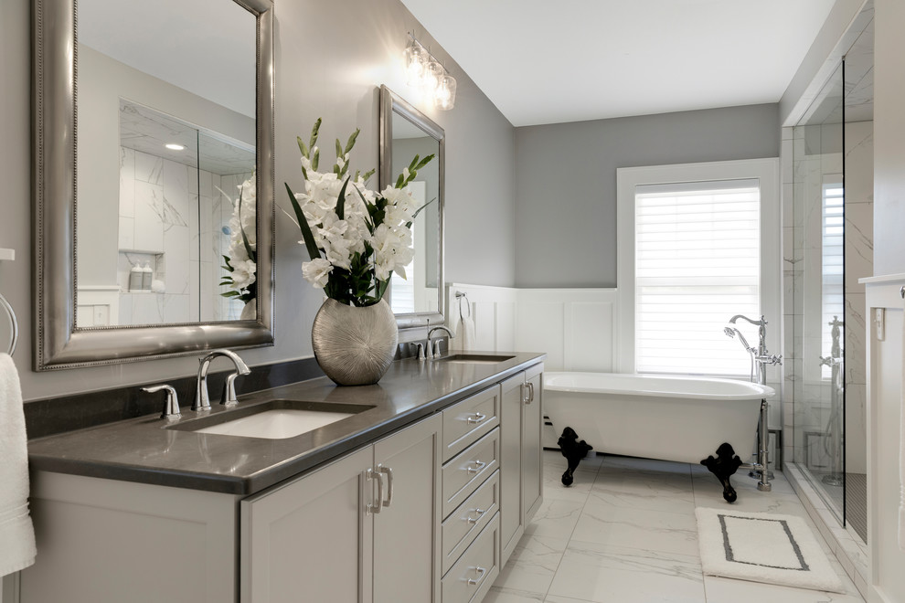 This is an example of a mid-sized transitional master bathroom in Minneapolis with recessed-panel cabinets, white cabinets, a claw-foot tub, gray tile, an undermount sink, a sliding shower screen and grey benchtops.