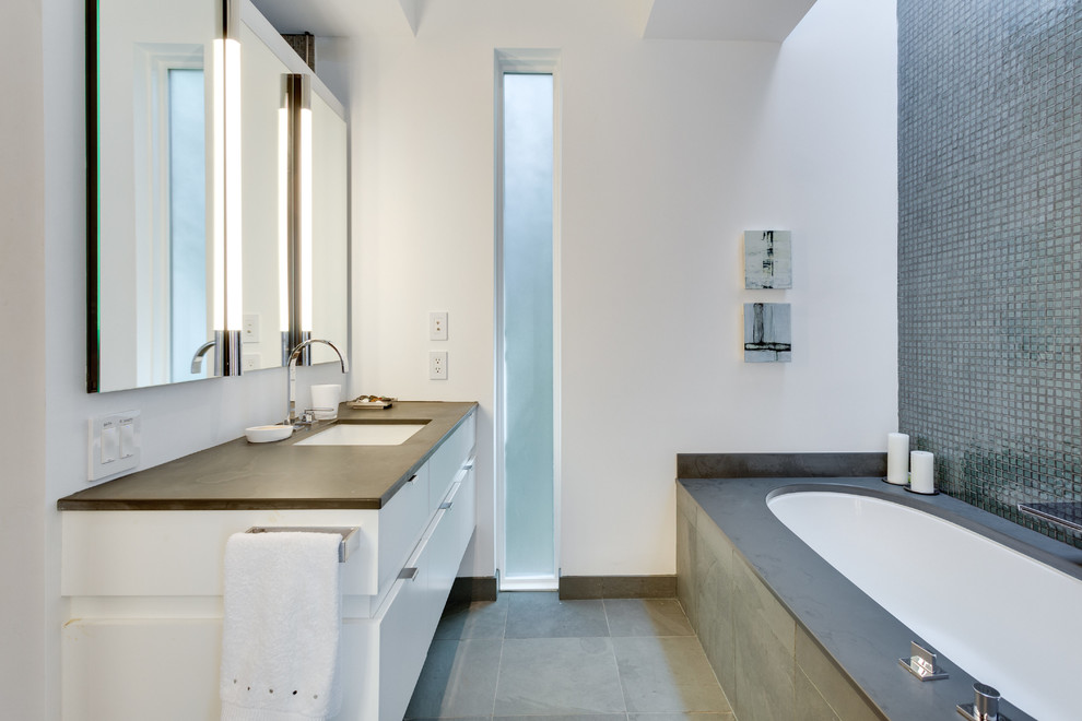 Photo of a mid-sized contemporary master bathroom in DC Metro with flat-panel cabinets, white cabinets, an undermount tub, a curbless shower, green tile, glass tile, white walls and slate floors.