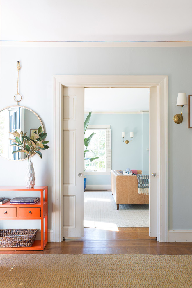 This is an example of an eclectic entryway in San Francisco with grey walls, medium hardwood floors, a single front door and a white front door.