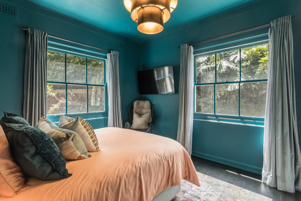 Idées déco pour une petite chambre parentale contemporaine avec un mur bleu, parquet foncé et un sol noir.