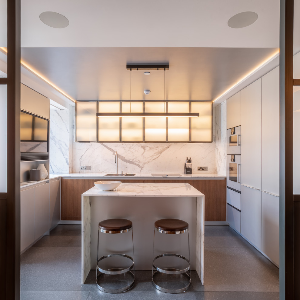 Photo of a mid-sized contemporary u-shaped separate kitchen in London with a drop-in sink, flat-panel cabinets, medium wood cabinets, marble benchtops, white splashback, marble splashback, stainless steel appliances, limestone floors, with island, grey floor, white benchtop and coffered.