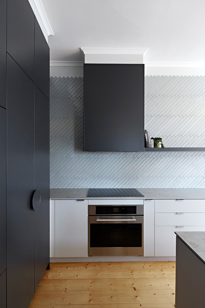Photo of a mid-sized modern l-shaped open plan kitchen in Melbourne with an undermount sink, blue splashback, stainless steel appliances, with island, grey benchtop, grey cabinets, quartz benchtops and ceramic splashback.