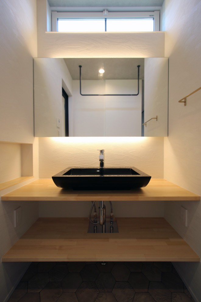 Photo of a modern cloakroom in Other with open cabinets, light wood cabinets, white walls, laminate floors, a trough sink, wooden worktops, multi-coloured floors, beige worktops, feature lighting, a built in vanity unit and wallpapered walls.