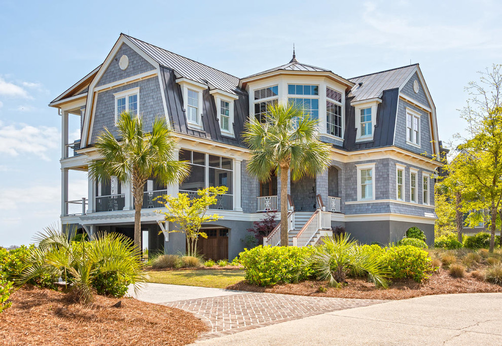 Inspiration for a beach style two-storey grey house exterior in Charleston with wood siding, a gambrel roof and a metal roof.