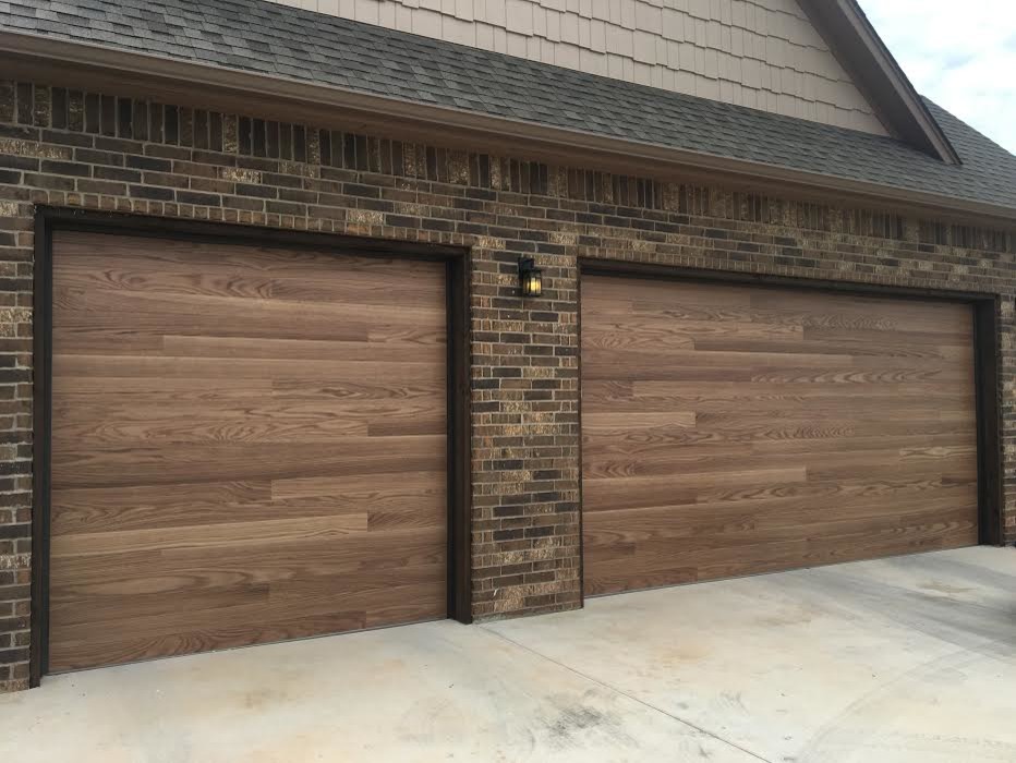 This is an example of a large contemporary attached three-car garage in Oklahoma City.