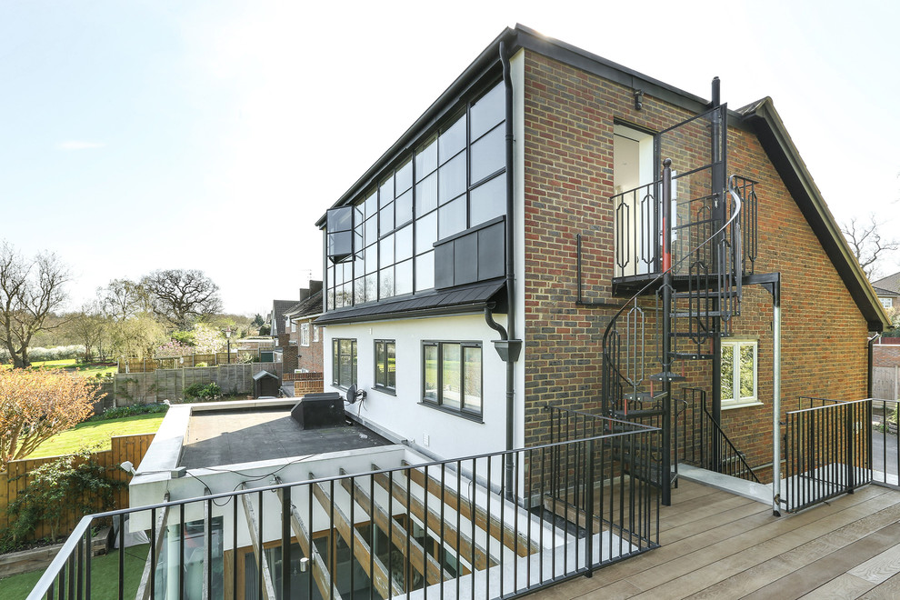 Photo of a mid-sized contemporary one-storey brick multi-coloured house exterior in London with a flat roof and a green roof.