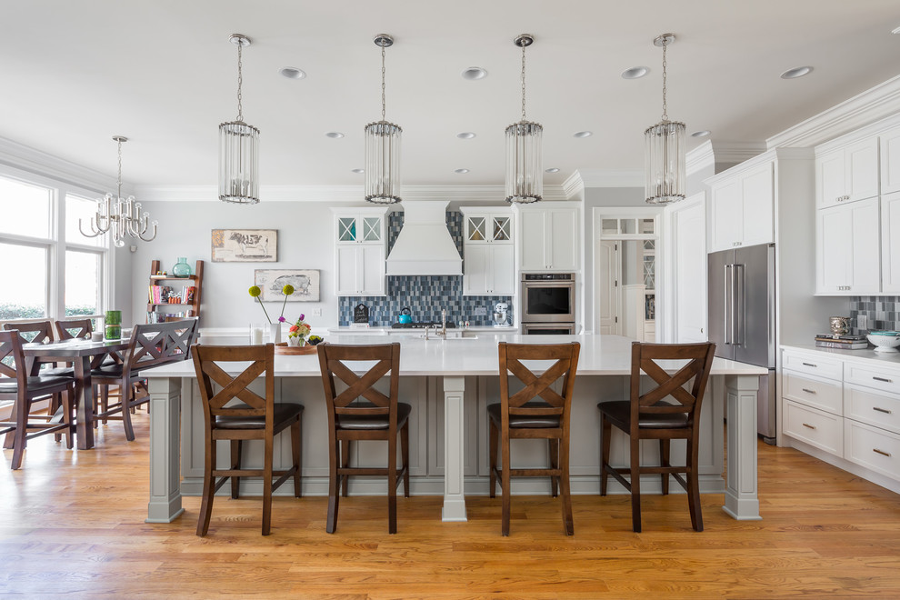 Eat-in kitchen - traditional medium tone wood floor eat-in kitchen idea in Raleigh with shaker cabinets, white cabinets, blue backsplash, mosaic tile backsplash, stainless steel appliances and an island