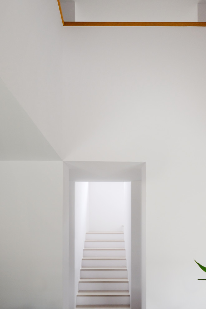 Exemple d'un escalier tendance en U et béton de taille moyenne avec un garde-corps en bois et du papier peint.