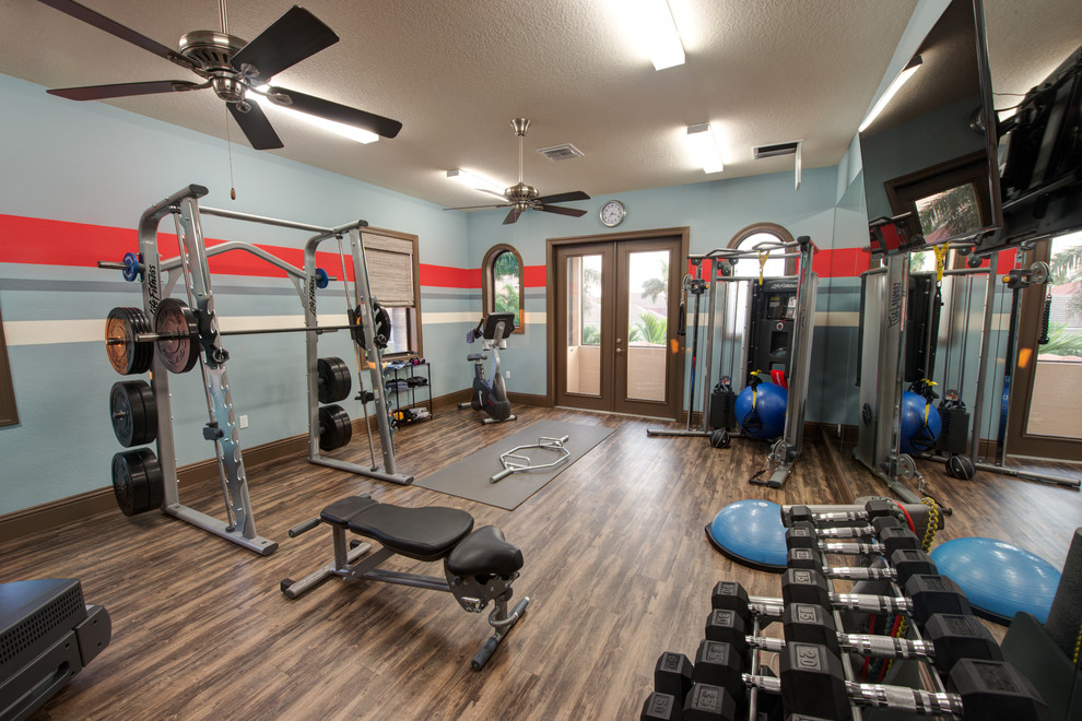 Photo of a mid-sized transitional multipurpose gym in Miami with multi-coloured walls, dark hardwood floors and brown floor.