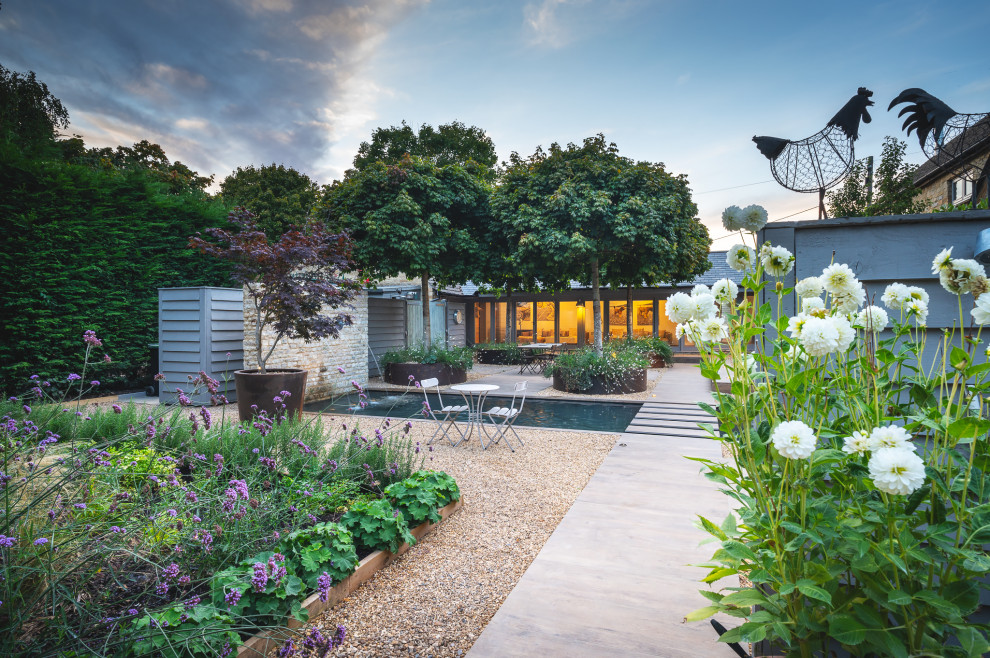 Small contemporary courtyard full sun formal garden in Oxfordshire with with waterfall for summer.