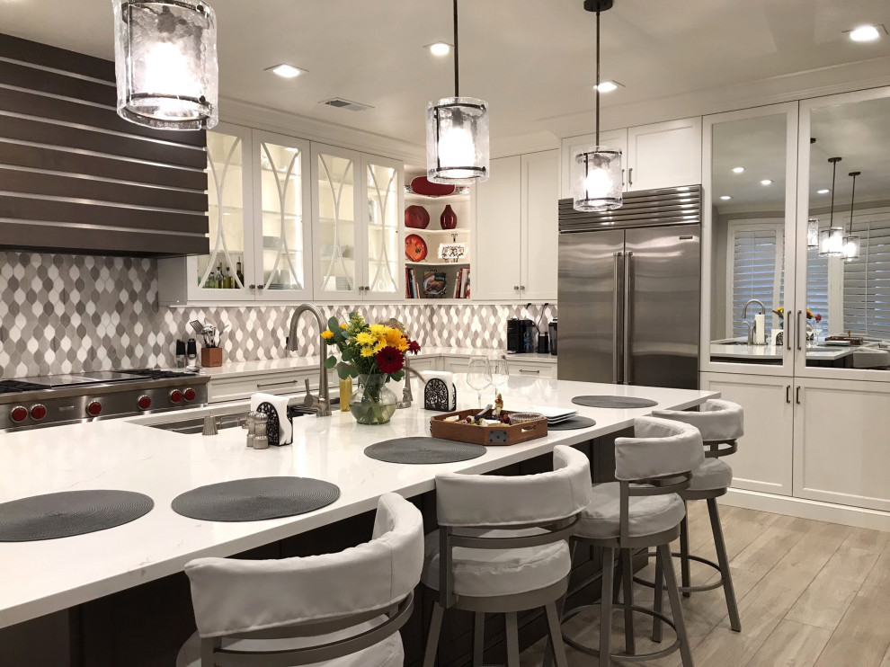 Design ideas for a large midcentury l-shaped kitchen in Orange County with an undermount sink, recessed-panel cabinets, white cabinets, quartz benchtops, multi-coloured splashback, ceramic splashback, stainless steel appliances, ceramic floors, with island, multi-coloured floor and white benchtop.