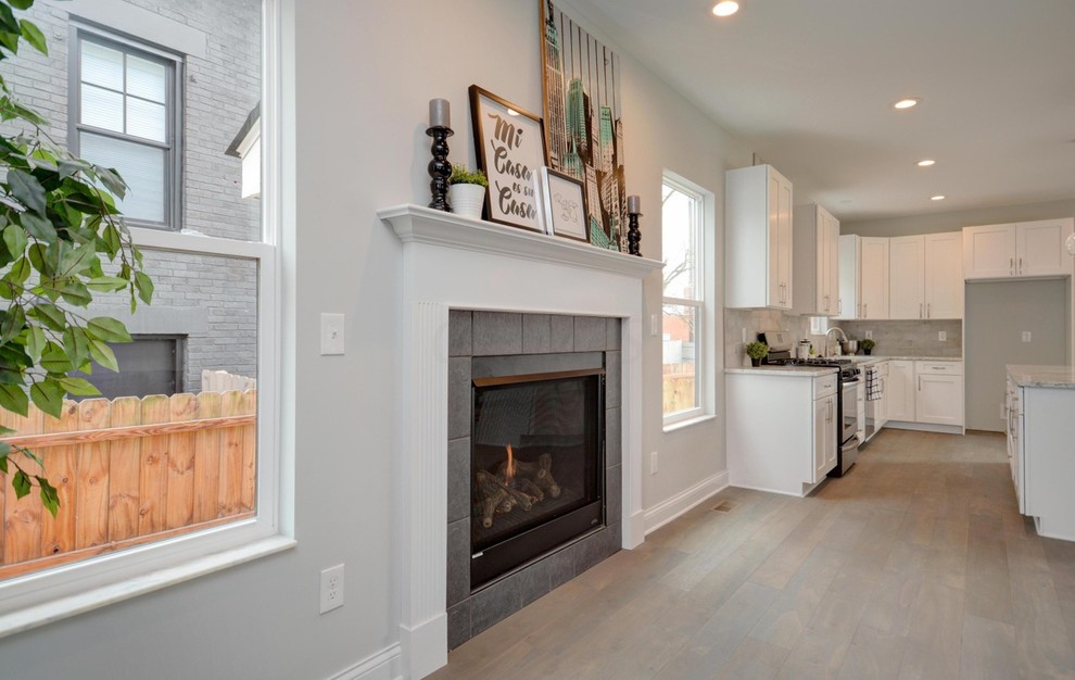 Inspiration for a mid-sized transitional formal open concept living room in Columbus with grey walls, light hardwood floors, a standard fireplace, a wood fireplace surround, beige floor and no tv.