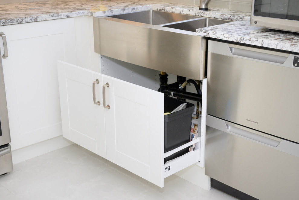 Large transitional u-shaped porcelain tile enclosed kitchen photo in Toronto with a farmhouse sink, white cabinets, beige backsplash, stainless steel appliances, no island, recessed-panel cabinets, quartzite countertops and ceramic backsplash