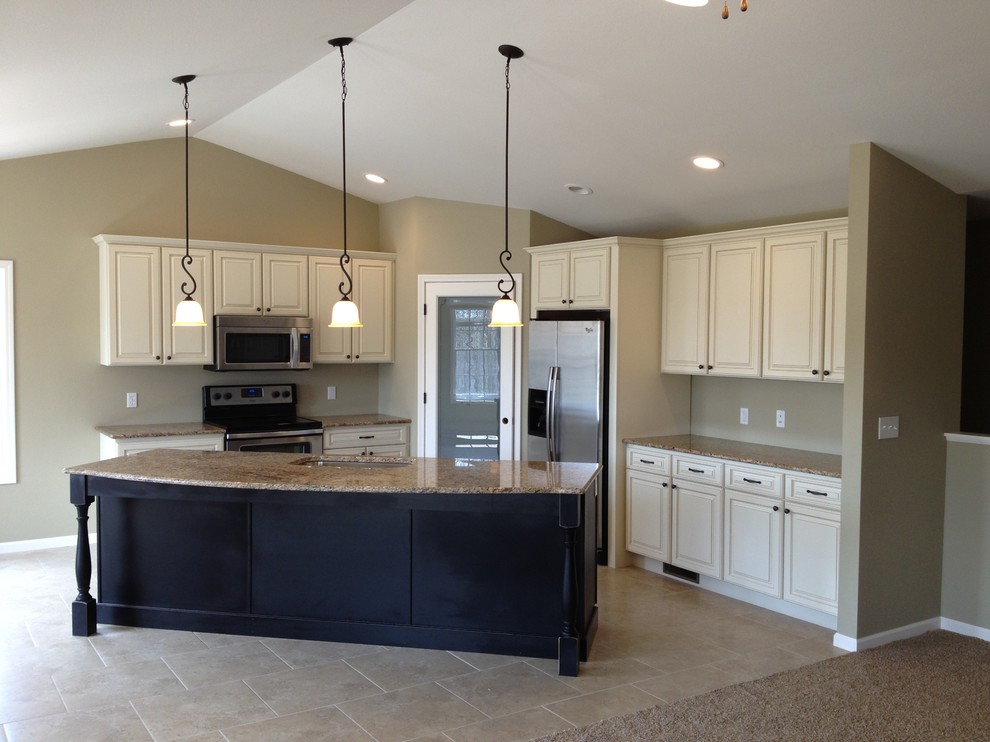 Inspiration for a transitional porcelain tile kitchen remodel with an undermount sink, raised-panel cabinets, black cabinets, granite countertops, beige backsplash and stainless steel appliances