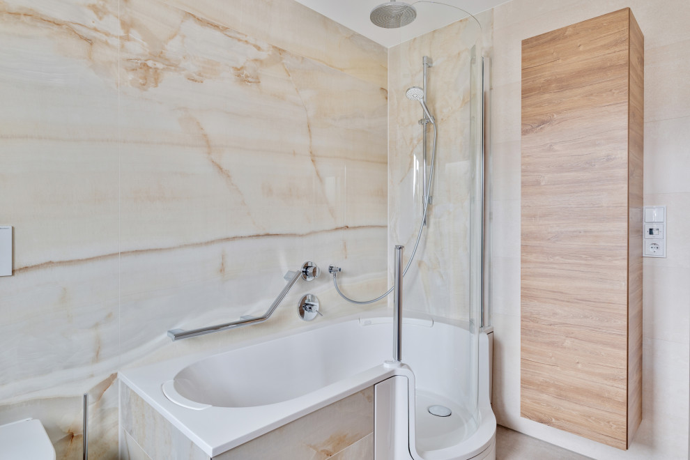 Modelo de cuarto de baño de pie tradicional con bañera encastrada, baldosas y/o azulejos de mármol y aseo y ducha