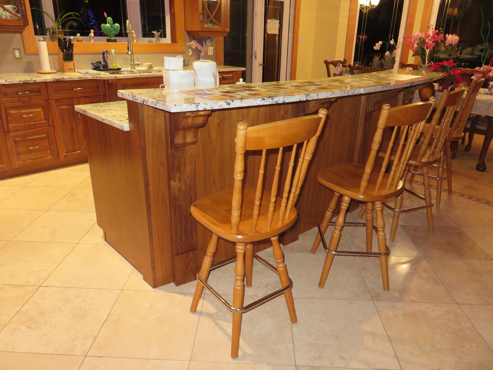 Open concept kitchen - large transitional l-shaped ceramic tile open concept kitchen idea with raised-panel cabinets, medium tone wood cabinets, granite countertops, stainless steel appliances, an island, a double-bowl sink, white backsplash and subway tile backsplash
