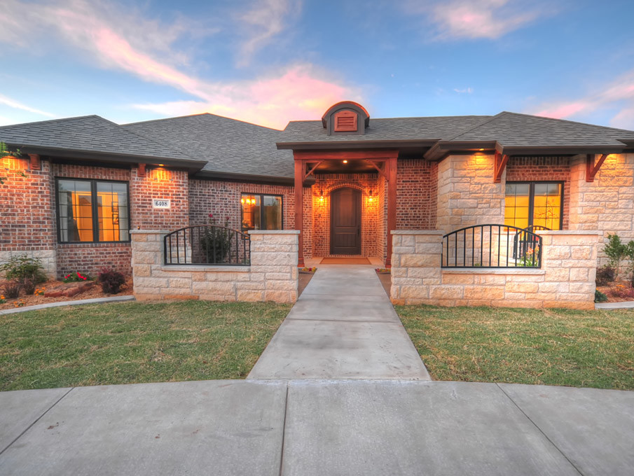 This is an example of a mid-sized country one-storey brick beige exterior in Austin with a hip roof.