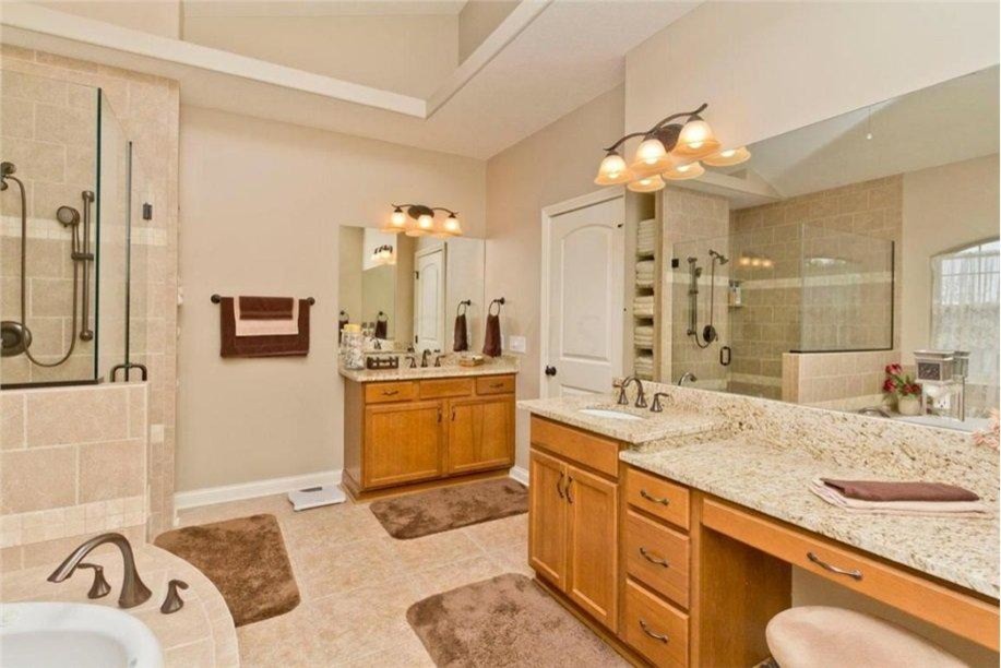 This is an example of a large traditional master bathroom in Columbus with an undermount sink, recessed-panel cabinets, light wood cabinets, granite benchtops, a drop-in tub, an open shower, a two-piece toilet, beige tile, ceramic tile, beige walls and ceramic floors.