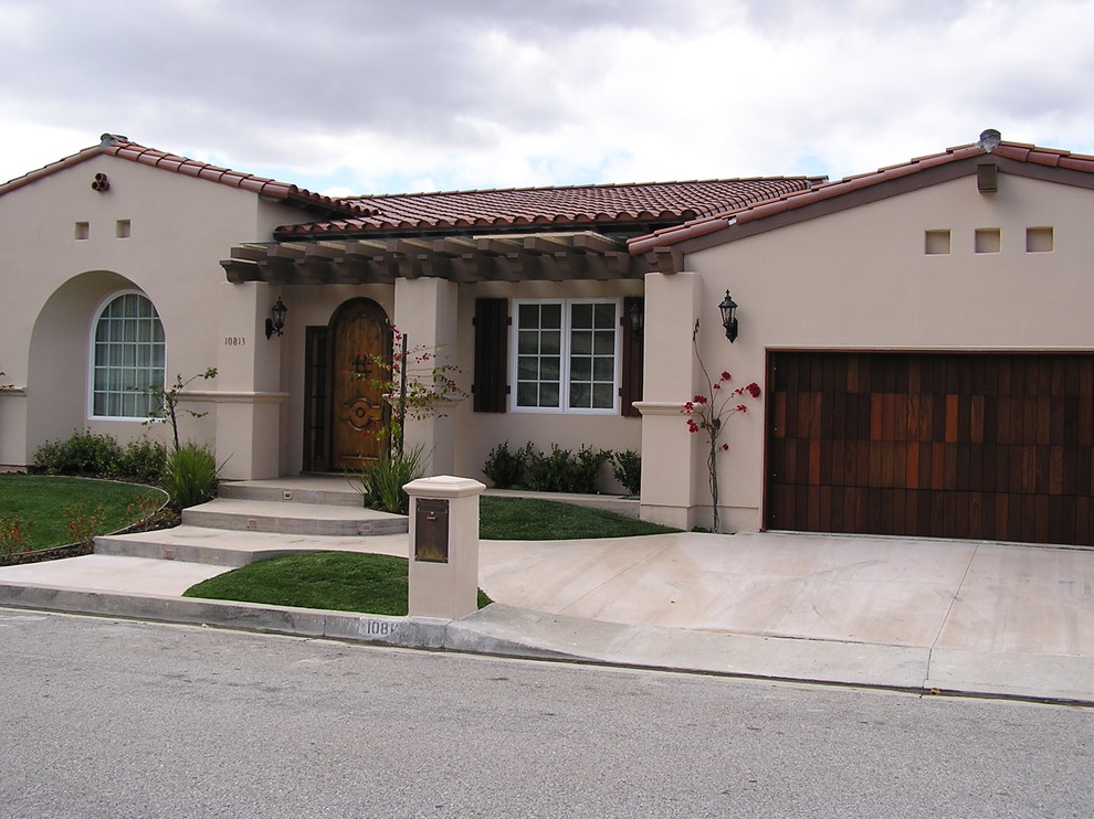 This is an example of a mid-sized one-storey stucco beige exterior in Los Angeles with a gable roof.