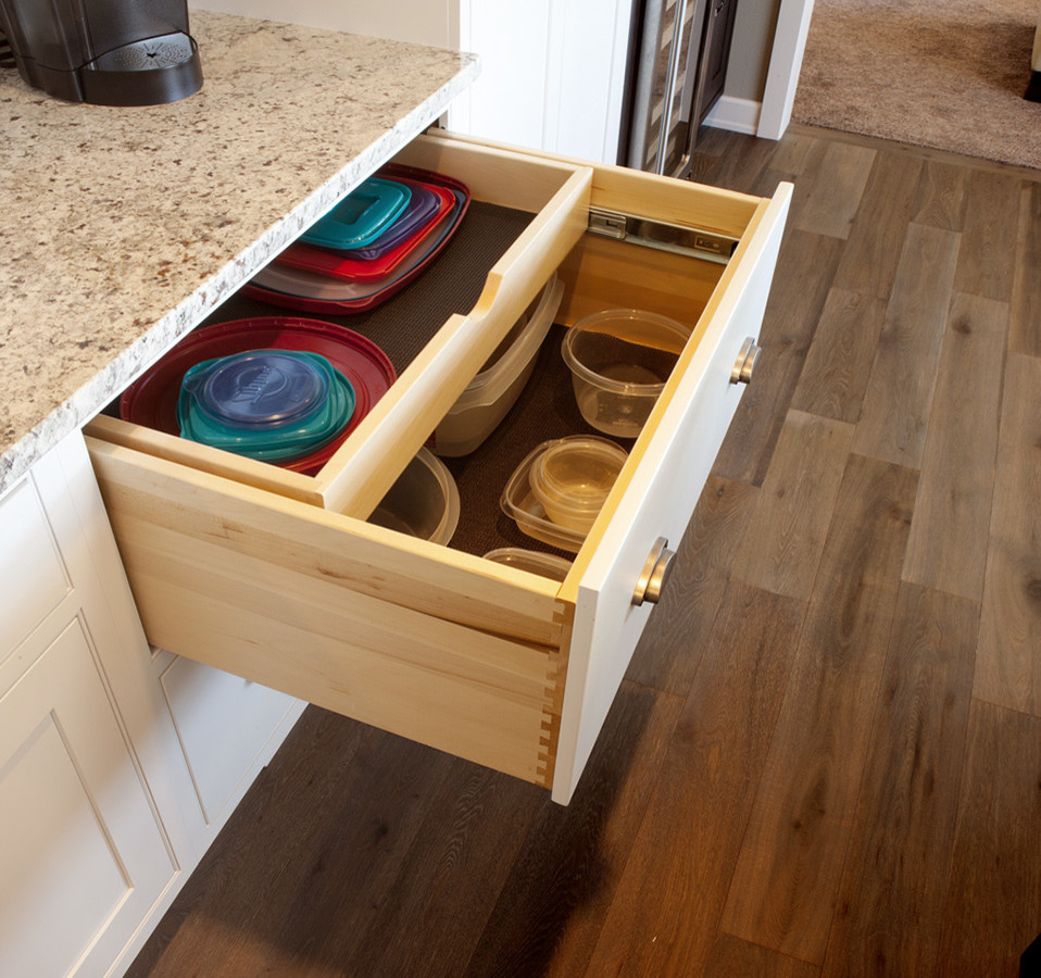 Example of a l-shaped kitchen design with stainless steel appliances and an island