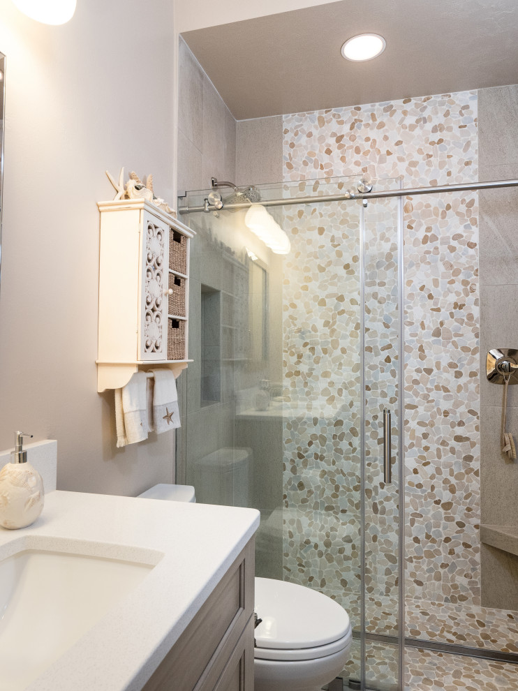 This is an example of a small transitional master bathroom in Jacksonville with flat-panel cabinets, light wood cabinets, an alcove shower, a two-piece toilet, beige tile, porcelain tile, beige walls, porcelain floors, an undermount sink, engineered quartz benchtops, beige floor, a sliding shower screen and white benchtops.