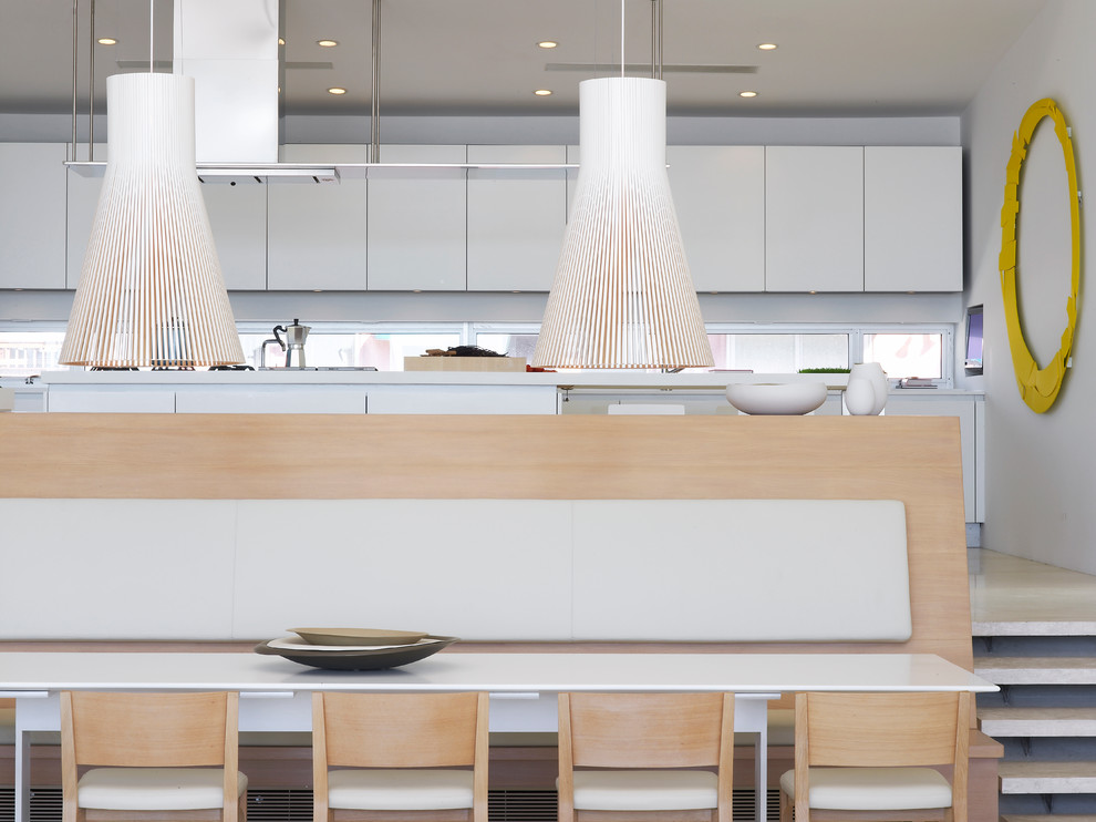 Photo of a modern kitchen/dining combo in New York with white walls.