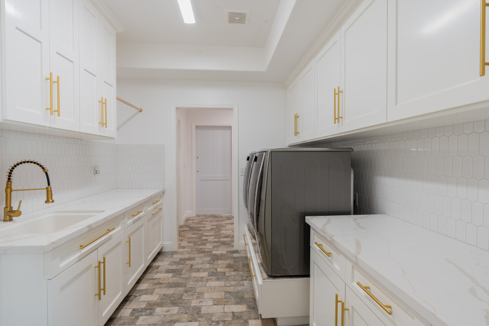 Laundry room - large modern galley brick floor and beige floor laundry room idea in Other with an undermount sink, recessed-panel cabinets, white cabinets, white backsplash, ceramic backsplash, white walls, a side-by-side washer/dryer, white countertops and quartz countertops