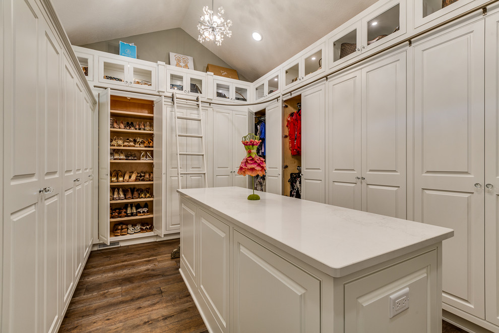 Design ideas for a traditional women's walk-in wardrobe in Cleveland with raised-panel cabinets, white cabinets, dark hardwood floors and brown floor.