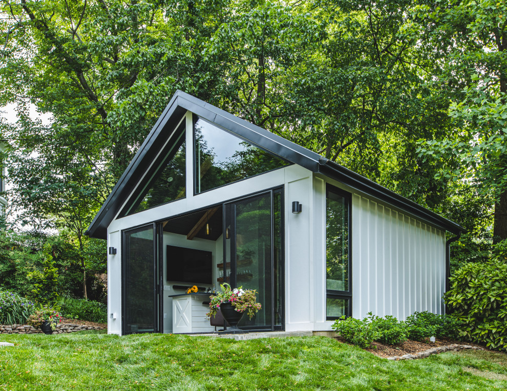 Diseño de fachada gris y negra minimalista pequeña de dos plantas con revestimiento de estuco, tejado a dos aguas, microcasa y tejado de metal
